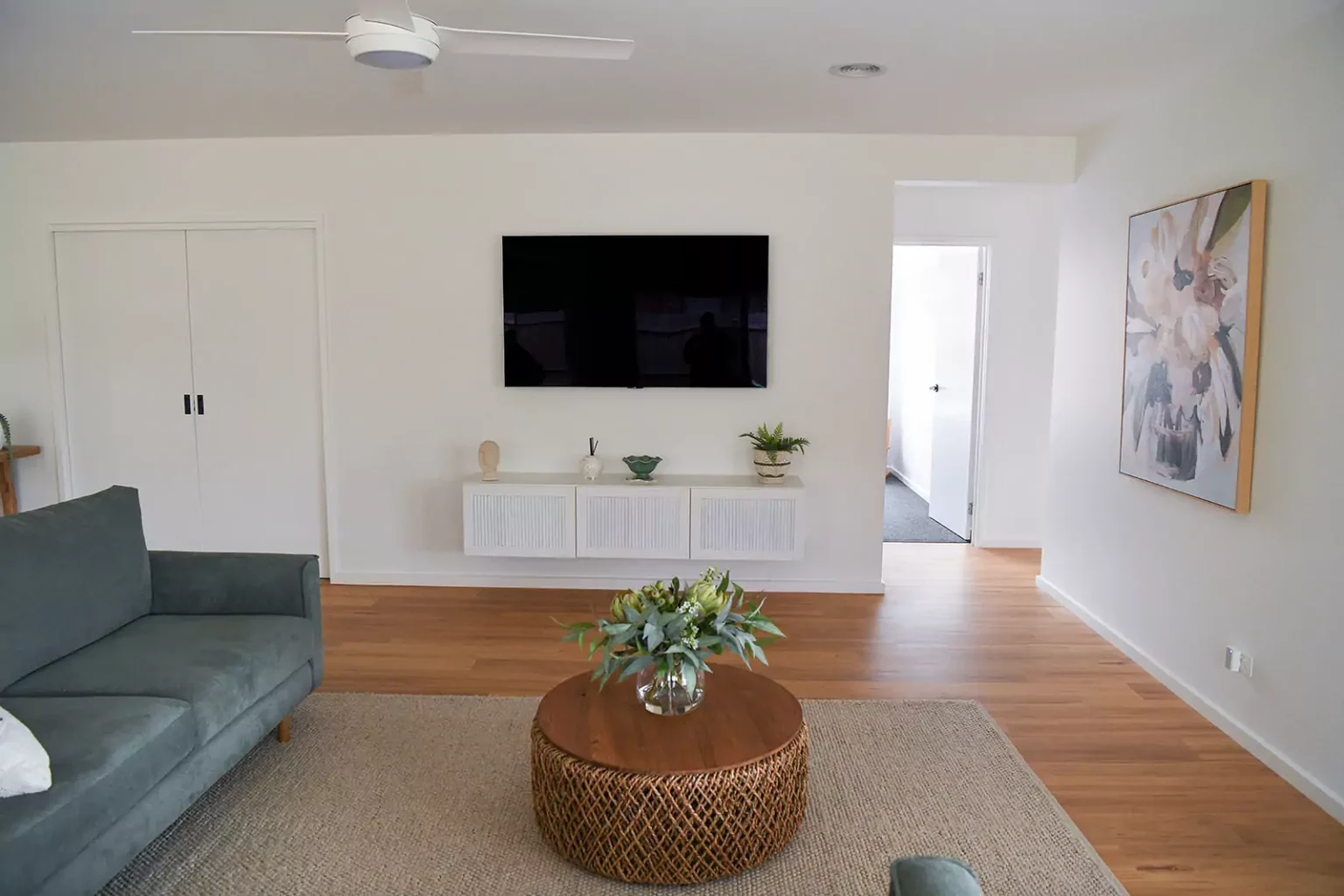 Living Room with couch, coffee table and TV mounted on wall