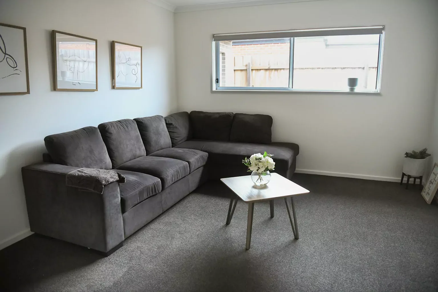 Living area with couch, coffee table and flowers in vase on coffee table