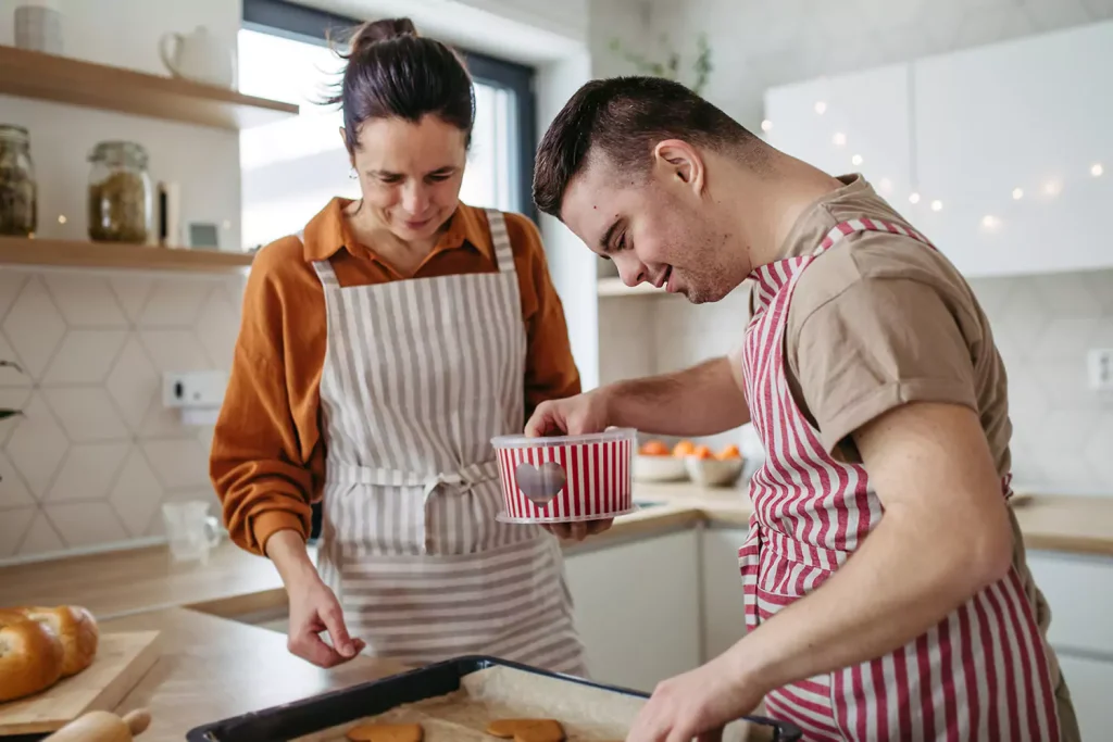 A disabled man and his support worker baking in the kitchen